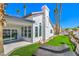 Exterior view featuring artificial turf, mature palms, and sleek black trim windows, creating an inviting outdoor living space at 1144 Calico Ridge Dr, Henderson, NV 89011