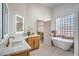 Elegant bathroom featuring a soaking tub, modern fixtures, a vanity, and an opening to a dressing room at 1144 Calico Ridge Dr, Henderson, NV 89011