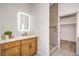 Stylish bathroom with a wood vanity, illuminated mirror, and a modern glass-enclosed shower at 1144 Calico Ridge Dr, Henderson, NV 89011