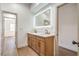 Well-lit bathroom showcasing a modern vanity with dual sinks and a large illuminated mirror at 1144 Calico Ridge Dr, Henderson, NV 89011