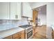 Modern kitchen boasts stainless gas range, sleek white cabinets, and modern countertops at 1144 Calico Ridge Dr, Henderson, NV 89011