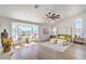 Bright main bedroom featuring tray ceilings, fan, large windows, and ensuite bathroom at 1144 Calico Ridge Dr, Henderson, NV 89011