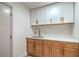 Convenient wet bar with a stainless steel sink, quartz counters, and modern wooden cabinets for easy entertaining at 1144 Calico Ridge Dr, Henderson, NV 89011