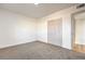 Bright bedroom featuring neutral carpet, white trim, and a closet for storing belongings at 1209 S 17Th St, Las Vegas, NV 89104