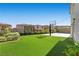 Backyard with lush artificial turf, mature landscaping, and a basketball court at 12413 Alpenglow Ct, Las Vegas, NV 89138