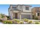 Charming two-story home with a gray stucco exterior, a two car garage, and a beautifully landscaped front yard at 12413 Alpenglow Ct, Las Vegas, NV 89138