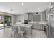 Modern kitchen boasts an island with seating, stainless appliances, and a sliding glass door to the backyard at 12413 Alpenglow Ct, Las Vegas, NV 89138