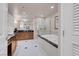 Elegant bathroom with a glass shower, soaking tub, and a dual sink vanity with wood cabinets and a large mirror at 145 E Harmon Ave # 3801&3803, Las Vegas, NV 89109