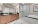 Bathroom with double vanity, large mirror, glass shower, and soaking tub at 145 E Harmon Ave # 3801&3803, Las Vegas, NV 89109