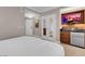 Bright bedroom features white linens, a kitchenette with modern appliances, and view into bathroom at 145 E Harmon Ave # 3801&3803, Las Vegas, NV 89109