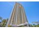 Modern high-rise building boasts sleek architecture, complemented by vibrant palm trees and clear blue skies at 145 E Harmon Ave # 3801&3803, Las Vegas, NV 89109