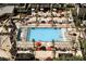 Aerial view of a luxurious pool area with palm trees, lounge chairs, and vibrant umbrellas at 145 E Harmon Ave # 3801&3803, Las Vegas, NV 89109