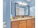 Bathroom with granite countertop, light wood cabinets, and a large mirror with modern lighting at 1455 E Katie Ave # D17, Las Vegas, NV 89119
