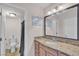 Bright bathroom with granite counters, wood cabinets, and a mirror, adjacent to shower at 1455 E Katie Ave # D17, Las Vegas, NV 89119