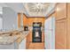 Bright kitchen featuring wood cabinets, granite countertops, and essential appliances at 1455 E Katie Ave # D17, Las Vegas, NV 89119