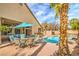 Beautiful pool and patio area with outdoor seating and lush palm trees creating a private backyard retreat at 1532 Via Cassia, Henderson, NV 89052