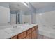 A bright bathroom featuring a double sink vanity and a tub with a white tile surround at 1532 Via Cassia, Henderson, NV 89052