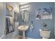 Charming powder room with pedestal sink, decorative art, and blue walls at 1532 Via Cassia, Henderson, NV 89052