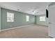 A spacious bedroom with multiple windows, a ceiling fan, and neutral carpet flooring at 1532 Via Cassia, Henderson, NV 89052