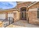 Elegant home entrance with stone accents, decorative iron gate, and a three-car garage at 1532 Via Cassia, Henderson, NV 89052