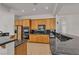 Well-lit kitchen featuring granite countertops, wooden cabinets, and stainless steel appliances at 1532 Via Cassia, Henderson, NV 89052