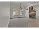 Open living room with stone fireplace and large windows overlooking the backyard at 1532 Via Cassia, Henderson, NV 89052