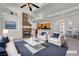 Bright living room featuring a stone fireplace, modern furnishings, and an open layout into the kitchen at 1532 Via Cassia, Henderson, NV 89052