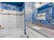 Stylishly designed bathroom with blue patterned wallpaper and marble tiled shower and backsplash at 1655 E Hacienda Ave, Las Vegas, NV 89119