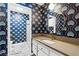 Stylish bathroom with striking wallpaper, round mirror, and quartz countertop at 1655 E Hacienda Ave, Las Vegas, NV 89119
