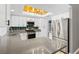 A modern kitchen featuring quartz countertops, stainless appliances, and a stunning light fixture at 1655 E Hacienda Ave, Las Vegas, NV 89119