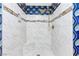 Luxurious shower with white marble tile, gold fixtures and mosaic accents at 1655 E Hacienda Ave, Las Vegas, NV 89119