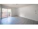 Bright, empty room with a sliding glass door to balcony featuring new gray flooring at 2606 S Durango Dr # 122, Las Vegas, NV 89117