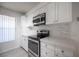 Updated kitchen with white cabinets, stone countertops, and stainless steel appliances at 2606 S Durango Dr # 122, Las Vegas, NV 89117
