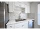 Kitchen sink features stone countertops, new backsplash and stainless steel dishwasher at 2606 S Durango Dr # 122, Las Vegas, NV 89117
