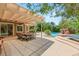 Expansive backyard featuring a covered patio, outdoor dining area, lush landscaping and custom pool with waterfall at 2940 Cimini Ct, Henderson, NV 89052