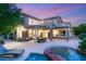 Beautiful backyard featuring a covered patio, outdoor dining area, and luxurious pool with spa at 2940 Cimini Ct, Henderson, NV 89052
