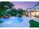 Expansive backyard showcasing a custom pool with waterfall feature and lush landscaping at 2940 Cimini Ct, Henderson, NV 89052