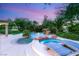Luxurious backyard pool and spa featuring rock accents, a waterfall, and lush tropical landscaping at 2940 Cimini Ct, Henderson, NV 89052
