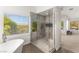 Bright bathroom featuring a modern glass shower and tub with a view to yard at 2940 Cimini Ct, Henderson, NV 89052