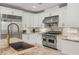 Close-up of the island, cooktop, and sink in a well-equipped kitchen with stainless appliances and granite countertops at 2940 Cimini Ct, Henderson, NV 89052