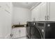 Organized laundry room with modern appliances, granite countertops, and ample storage cabinets at 2940 Cimini Ct, Henderson, NV 89052