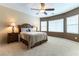 Spacious bedroom with a ceiling fan, neutral carpet, and multiple windows for natural light at 2970 Strathspey Ct, Henderson, NV 89044
