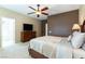 Large bedroom with a ceiling fan, carpet flooring, and TV on wooden dresser at 2970 Strathspey Ct, Henderson, NV 89044