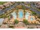 Aerial view of a pool with chairs and tables surrounded by palm trees and well-maintained landscaping at 30 Via Vasari # 102, Henderson, NV 89011