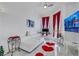 Bright bedroom with red accent rugs, decor, and curtains plus white furniture and tile floors at 30 Via Vasari # 102, Henderson, NV 89011