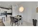 Bright dining area featuring modern lighting and clear chairs next to the kitchen at 30 Via Vasari # 102, Henderson, NV 89011
