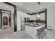 Modern kitchen featuring white cabinets, a marble-topped island with stools, stainless steel appliances, and dark backsplash at 30 Via Vasari # 102, Henderson, NV 89011
