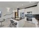 Stylish kitchen island with marble countertop and stainless appliances, adjacent to seating and a staircase at 30 Via Vasari # 102, Henderson, NV 89011