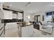 Open concept kitchen with a marble island, white cabinets, stainless appliances, and an adjacent living area at 30 Via Vasari # 102, Henderson, NV 89011