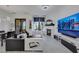 Open-concept living room with fireplace, TV, modern furnishings and white tile floors at 30 Via Vasari # 102, Henderson, NV 89011
